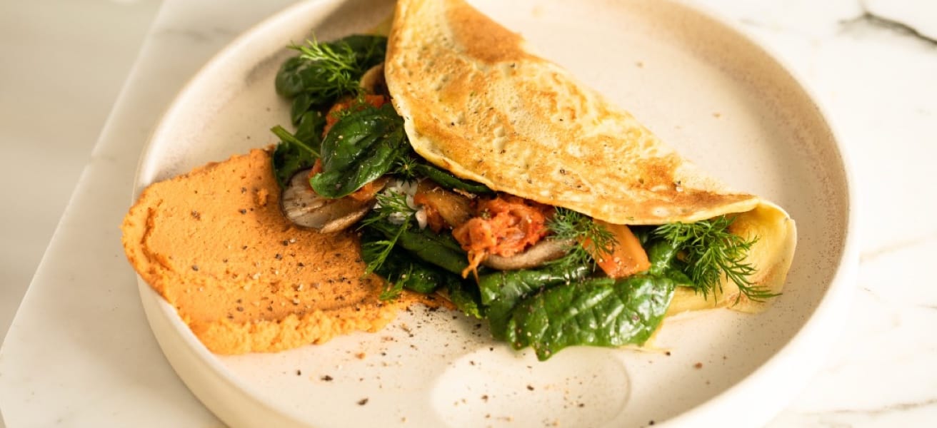 Omelet filled with vegetables and seasonings arranged on a plate